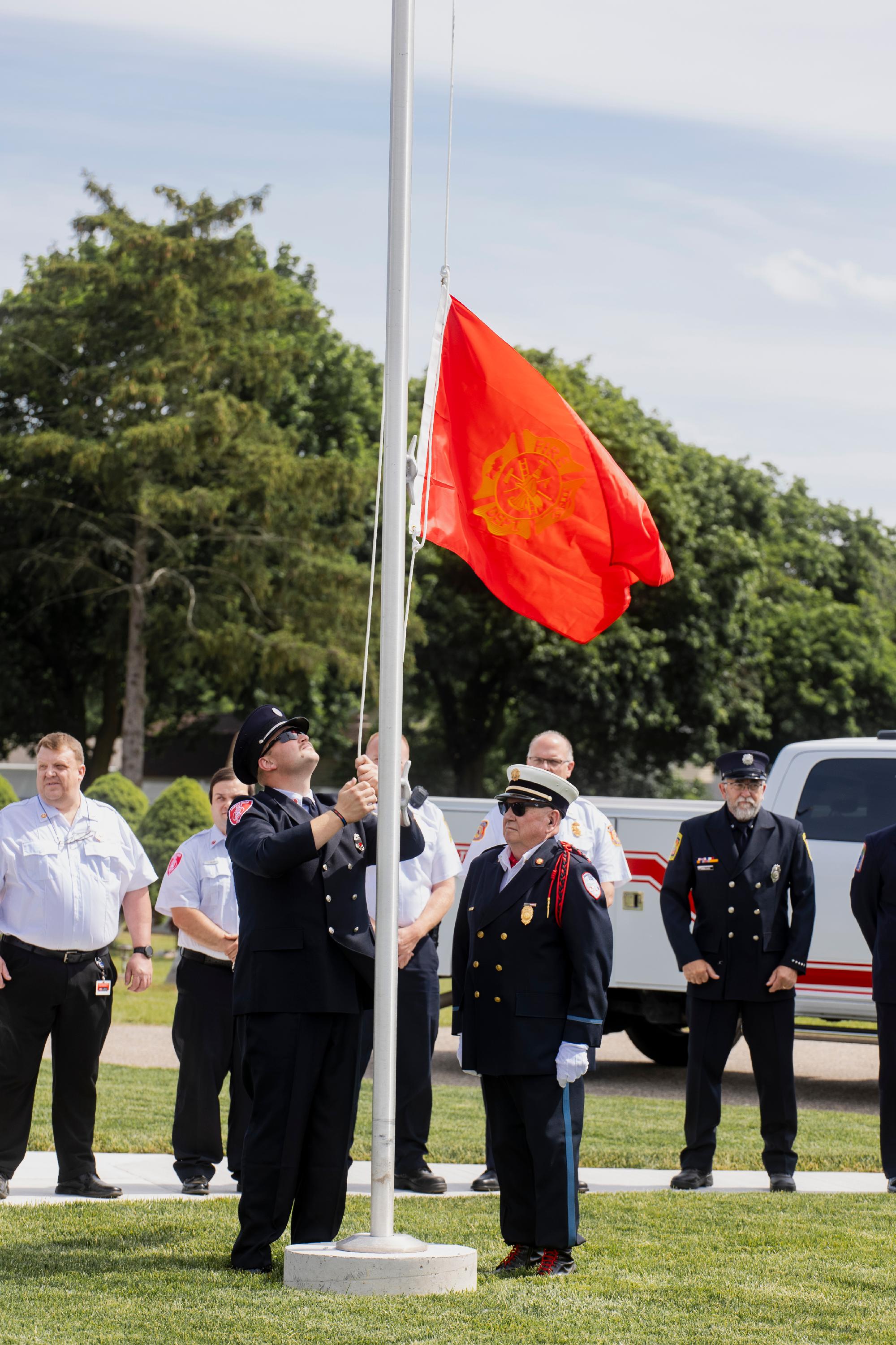 A diverse group of people gathered around a flag, smiling and engaging in conversation